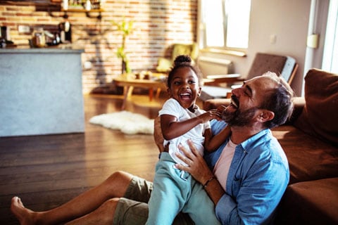 Father and child hugging and laughing